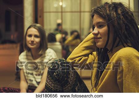 Stock Photograph - Caucasian women sitting in living room. Fotosearch