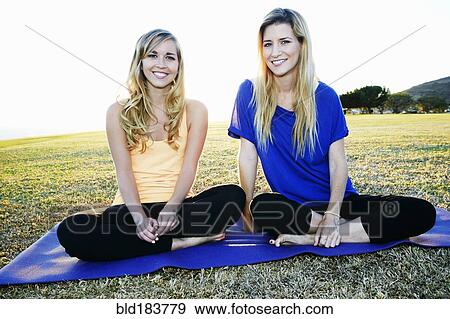Caucasian women sitting on yoga mat in field View Large Photo Image Stock Photo - Caucasian women sitting on yoga mat in field. Fotosearch