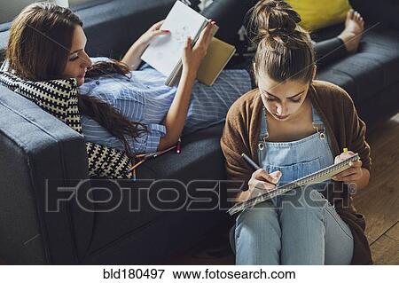 Stock Photo - Caucasian women studying in living room. Fotosearch