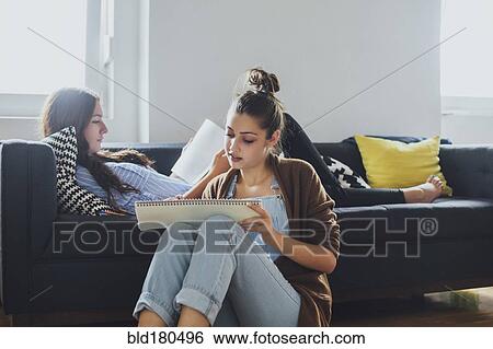 Caucasian women studying in living room View Large Photo Image Stock Photograph - Caucasian women studying in living room. Fotosearch