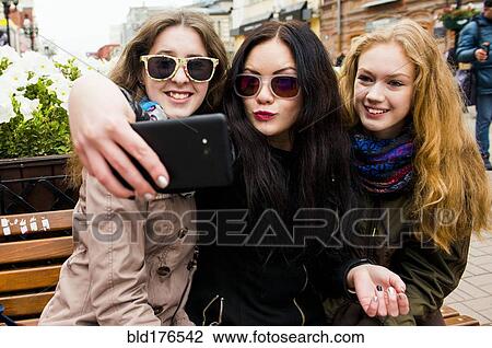 Caucasian women taking selfie on bench View Large Photo Image Stock Image - Caucasian women taking selfie on bench. Fotosearch