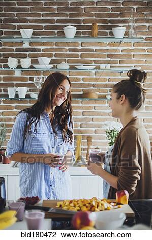 Caucasian women talking in kitchen View Large Photo Image Stock Image - Caucasian women talking in kitchen. Fotosearch