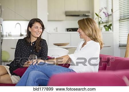 Caucasian women talking on sofa View Large Photo Image Stock Photo - Caucasian women talking on sofa. Fotosearch