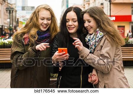 Caucasian women using cell phone outdoors View Large Photo Image Stock Photography - Caucasian women using cell phone outdoors. Fotosearch