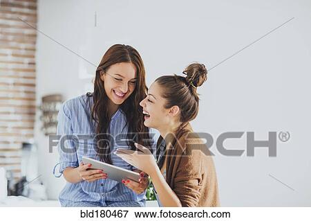 Stock Photo - Caucasian women using digital tablet. Fotosearch