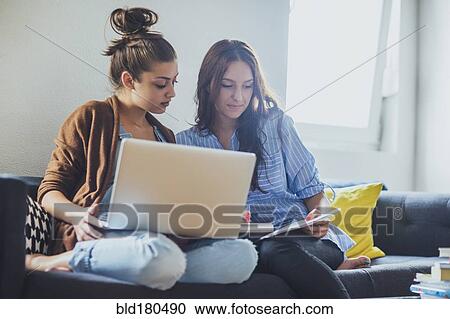 Caucasian women using laptop on sofa View Large Photo Image Stock Image - Caucasian women using laptop on sofa. Fotosearch