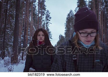 Stock Photo - Caucasian women walking in snowy forest. Fotosearch