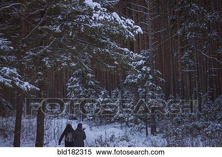 Stock Photography - Caucasian women walking in snowy forest. Fotosearch