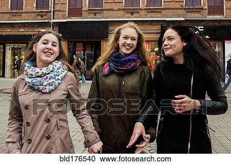 Stock Image - Caucasian women walking outdoors. Fotosearch