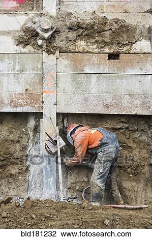 Stock Image - Caucasian worker at construction site. Fotosearch