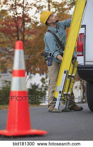Caucasian worker loading ladder on truck View Large Photo Image Stock Image - Caucasian worker loading ladder on truck. Fotosearch