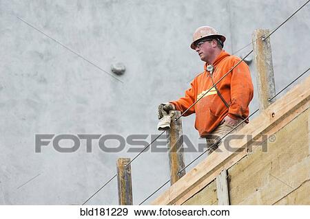 Caucasian worker standing at construction site View Large Photo Image Stock Photo - Caucasian worker standing at construction site. Fotosearch
