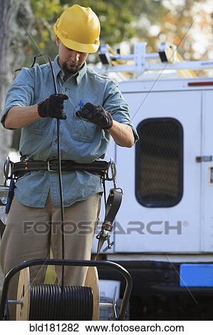 Caucasian worker unrolling cable spool View Large Photo Image Stock Image - Caucasian worker unrolling cable spool. Fotosearch
