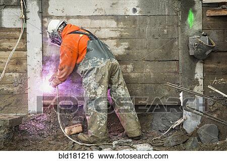 Caucasian worker welding at construction site View Large Photo Image Stock Photograph - Caucasian worker welding at construction site. Fotosearch
