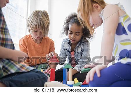 Children playing with blocks on floor View Large Photo Image Stock Photo - Children playing with blocks on floor. Fotosearch