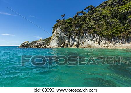 Stock Photograph - Cliff over ocean in remote beach. Fotosearch