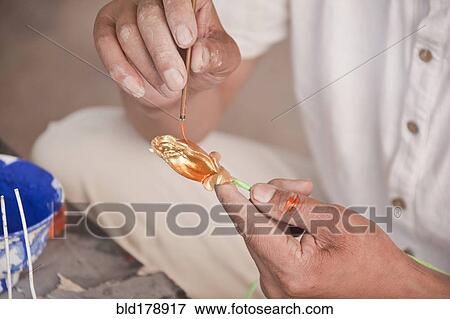 Stock Photo - Close up of artist painting glass ornament. Fotosearch