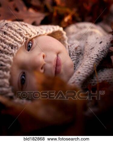 Close up of baby boy laying in autumn leaves View Large Photo Image Stock Photo - Close up of baby boy laying in autumn leaves. Fotosearch