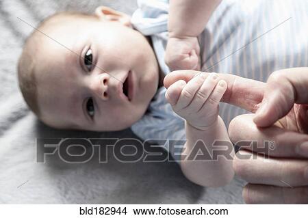 Close up of baby boy playing with fingers of father View Large Photo Image Picture - Close up of baby boy playing with fingers of father. Fotosearch