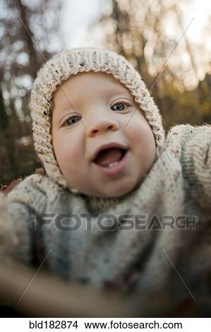 Picture - Close up of baby boy smiling outdoors. Fotosearch