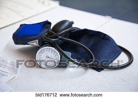 Stock Image - Close up of blood pressure cuff on table. Fotosearch