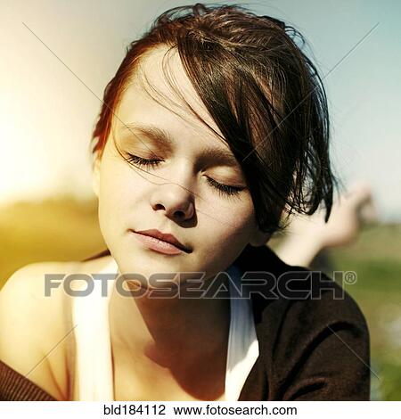 Stock Image - Close up of Caucasian teenage girl with eyes closed. Fotosearch