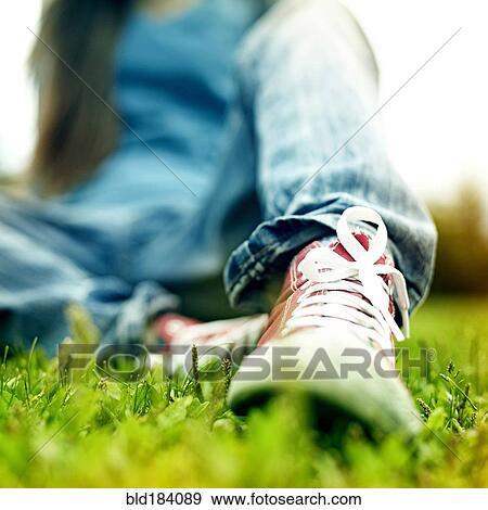 Stock Photo - Close up of Caucasian woman wearing sneakers. Fotosearch