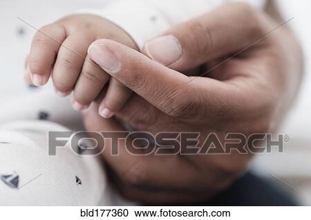 Close up of father holding hand of baby son View Large Photo Image Stock Image - Close up of father holding hand of baby son. Fotosearch