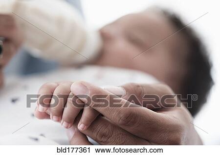 Close up of father holding hand of baby son View Large Photo Image Stock Image - Close up of father holding hand of baby son. Fotosearch
