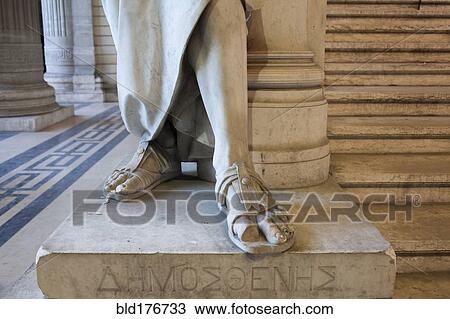 Stock Image - Close up of feet of carved statue on marble pedestal. Fotosearch