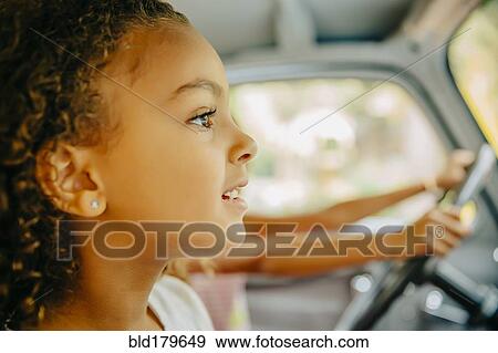 Close up of girl sitting in car View Large Photo Image Stock Photo - Close up of girl sitting in car. Fotosearch