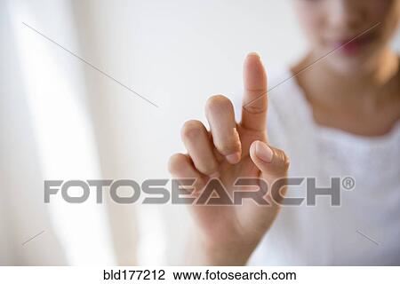 Stock Image - Close up of Hispanic woman pointing. Fotosearch