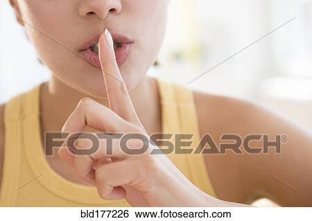 Stock Photograph - Close up of Hispanic woman shushing. Fotosearch