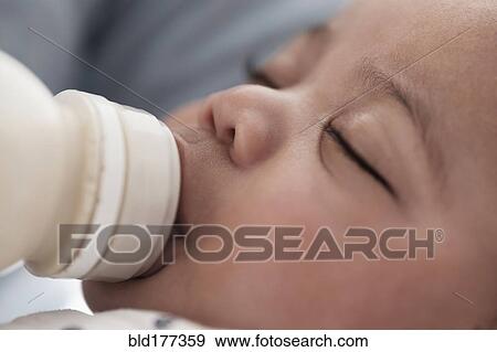 Stock Photo - Close up of mixed race boy bottle feeding. Fotosearch