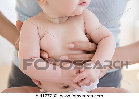 Stock Image - Close up of mother holding baby. Fotosearch