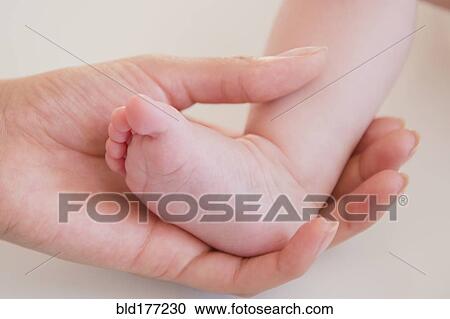 Close up of mother holding bare foot of baby View Large Photo Image Stock Image - Close up of mother holding bare foot of baby. Fotosearch