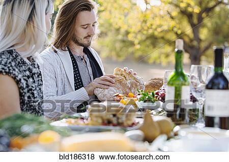 Couple eating at outdoor table View Large Photo Image Stock Photo - Couple eating at outdoor table. Fotosearch