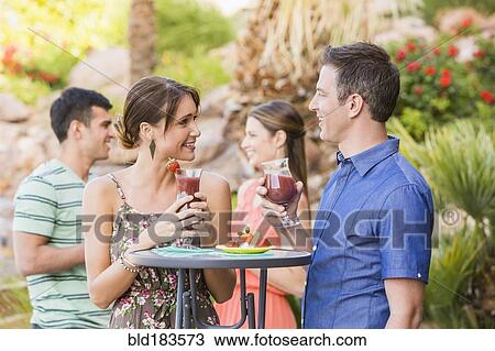 Couple having cocktail at outdoor patio View Large Photo Image Stock Image - Couple having cocktail at outdoor patio. Fotosearch