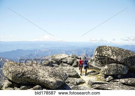 Couple hiking on rocky hilltop View Large Photo Image Stock Photo - Couple hiking on rocky hilltop. Fotosearch