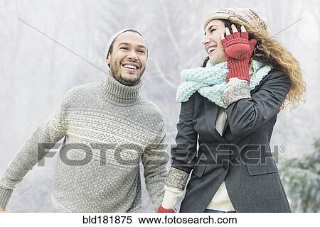 Stock Photography - Couple holding hands in snow. Fotosearch