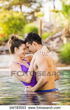 Couple hugging in swimming pool View Large Photo Image Stock Image - Couple hugging in swimming pool. Fotosearch