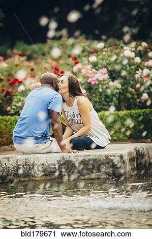 Couple kissing at fountain in garden View Large Photo Image Stock Image - Couple kissing at fountain in garden. Fotosearch