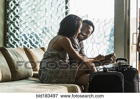 Stock Photo - Couple sitting on hotel lobby sofa. Fotosearch