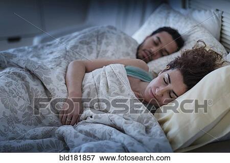 Stock Photo - Couple sleeping in bed. Fotosearch
