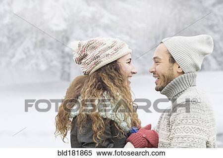 Stock Photography - Couple smiling in snow. Fotosearch