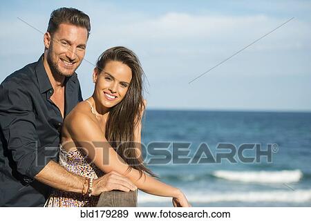 Couple standing on beach pier View Large Photo Image Stock Photo - Couple standing on beach pier. Fotosearch