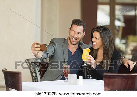 Stock Photo - Couple taking selfie in restaurant. Fotosearch