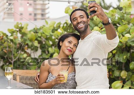 Stock Image - Couple taking selfie outdoors. Fotosearch