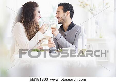 Stock Image - Couple toasting each other with wine. Fotosearch