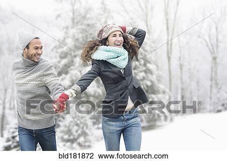 Stock Image - Couple walking in snow. Fotosearch